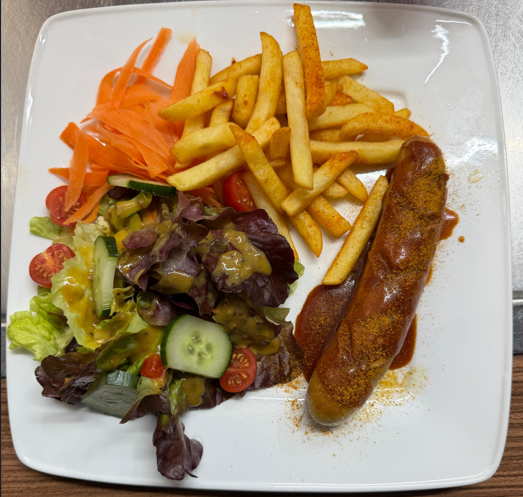 Hausgemachte Currywurst mit Pommes und Salat